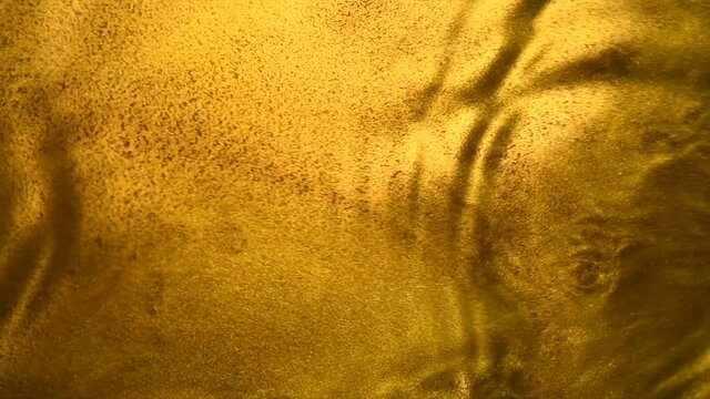 Liquid gold abstract background. Flowing Golden abstract backdrop. Beautiful metallic yellow texture. Liquid Gold metallic paint close-up. Art Wallpaper 