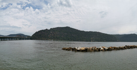 Beautiful panoramic view of a river on a cloudy day with tall mountains and trees in the background, Hawkesbury river, Deerubbun Reserve, Mooney Mooney, New South Wales, Australia
