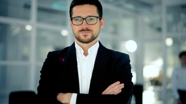 Close up portrait of young startup founder standing at office room and looking to camera. Concept of work , business, it industry