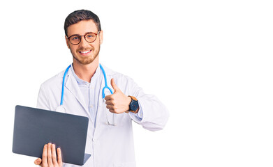 Handsome young man with bear wearing doctor uniform working using computer laptop smiling happy and positive, thumb up doing excellent and approval sign