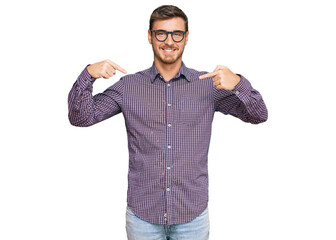 Handsome caucasian man wearing casual clothes and glasses looking confident with smile on face,...