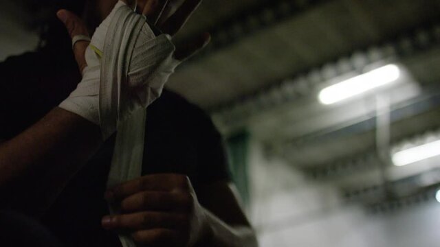 Young black boxer using a hand wrap to protect his hands before training
