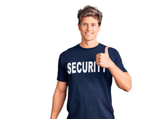 Young handsome man wearing security t shirt doing happy thumbs up gesture with hand. approving expression looking at the camera showing success.