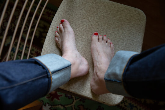 woman's feet and cuffed denim jeans