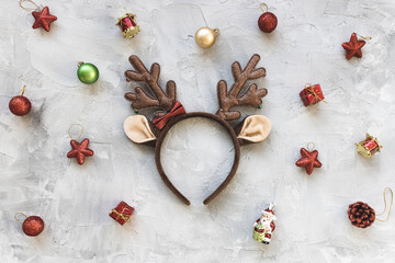 Moody winter holidays red and white background with deer costume handband and holiday decoration. Festive abstract backround. Christmas celebration, New Year party concept