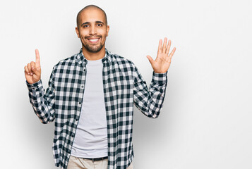Hispanic adult man wearing casual clothes showing and pointing up with fingers number six while smiling confident and happy.