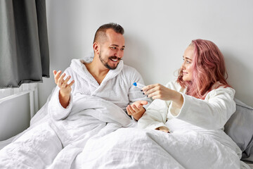 man happily react on test of pregnancy, joyful couple finding out results of a pregnancy test at home lying on bed