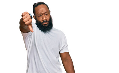 Young african american man wearing casual white tshirt looking unhappy and angry showing rejection and negative with thumbs down gesture. bad expression.