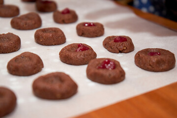 Chocolate Dough And Cherry Jam On A Sheet Of Baking Paper Intended To Be Baked To Become Cookies