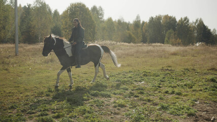 A young rider sets off early in the morning on a long horse ride through rough terrain and woods.