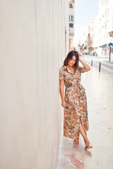 Fototapeta premium Beautiful young woman wearing fashionable clothes walking down the street