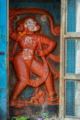 Hampi, Karnataka, India - November 4, 2013: Virupaksha Temple complex. Closeup of red painted mural sculpture of Hanuman near Shiva Sanctum. Blues and greens add color.