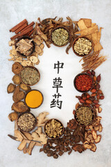 Chinese healing herb collection used in traditional herbal medicine with calligraphy script on rice paper with mottled grey background. Flat lay. Translation reads as chinese healing herbs. 
