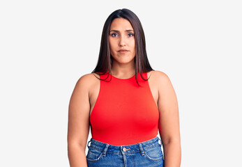 Obraz premium Young beautiful brunette woman wearing casual sleevelss t-shirt with serious expression on face. simple and natural looking at the camera.