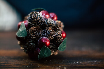 closeup photo of a Christmas decoration feturing gold-dusted cones and red berries - 397916703
