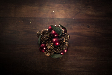 closeup photo of a Christmas decoration feturing gold-dusted cones and red berries - 397916745