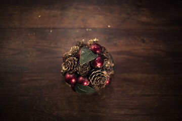 closeup photo of a Christmas decoration feturing gold-dusted cones and red berries - 397916754