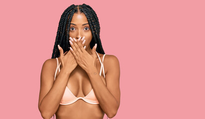Beautiful hispanic woman wearing bikini shocked covering mouth with hands for mistake. secret...