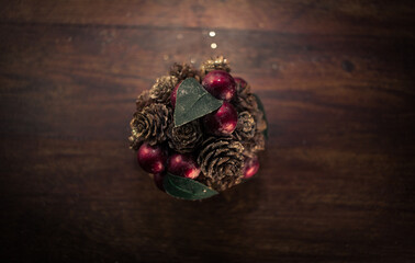 closeup photo of a Christmas decoration feturing gold-dusted cones and red berries - 397916768