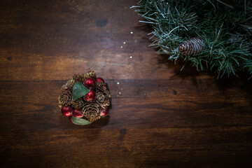 closeup photo of a Christmas decoration feturing gold-dusted cones and red berries - 397916788