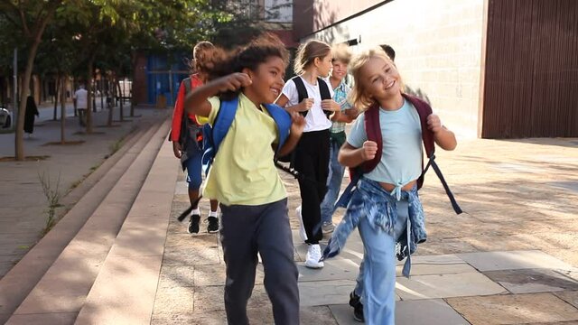 Kids spending time together outdoors walking after lessons at warm autumn day