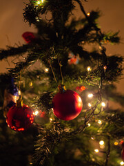 Christmas tree decorated with red balls, chocolates and lights