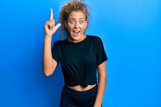 Beautiful caucasian teenager girl wearing black sportswear pointing finger up with successful idea. exited and happy. number one.