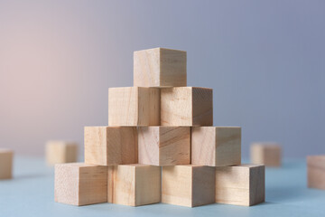 Concept of business growth to success. Stack of wooden cube as pyramid stairs with selective focus and depth of field.