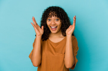 Young african american afro woman isolated receiving a pleasant surprise, excited and raising hands.