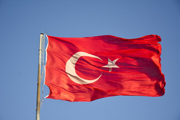 Turkish flag waving in the wind. Blue sky on background