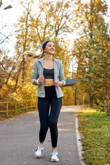 pretty athletic female running at sunny autumn day, enjoy the jogging. aport and wellbeing concept