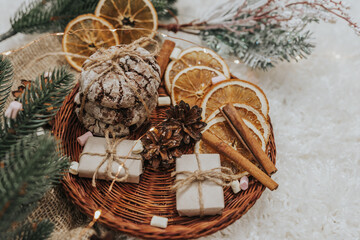 Still life details in home interior. Cozy winter concept with cinnamon, pine cones, cookies, marshmallows and gifts