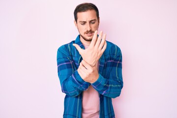 Young handsome man wearing casual clothes suffering pain on hands and fingers, arthritis inflammation