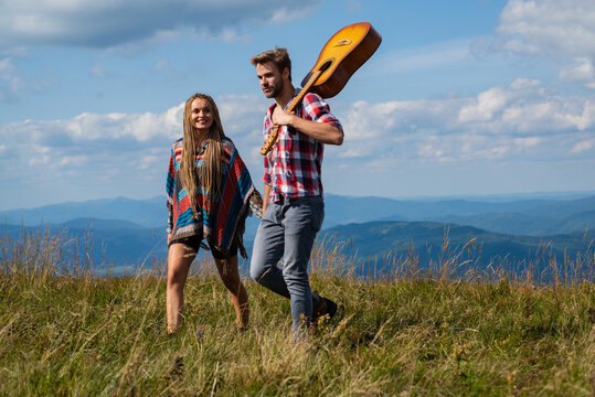 Young couple of tourists are exploring new places together. Attractive woman and handsome man are walking and spending time together on nature.