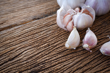 Organic garlic cloves and bulb on wood