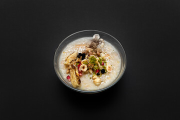 Closeup of traditional Turkish Dessert Asure or Ashura (aka Noah Pudding) in white bowls isolated on black backgroun