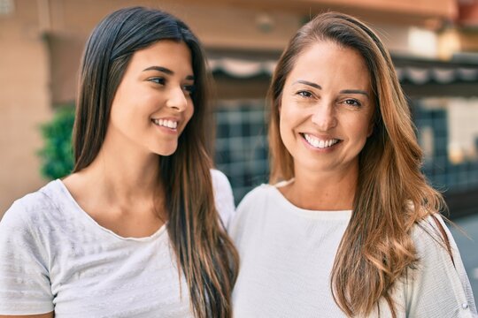 Beautiful hispanic mother and daughter smiling happy standing at the city.