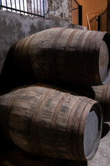 Old porto lodge with rows of oak wooden casks for slow aging of fortified ruby or tawny porto wine in Vila Nova de Gaia, Portugal