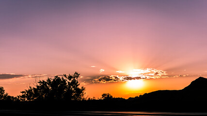 Panorama shot of colorful sunset behind clouds in Badland national park in america