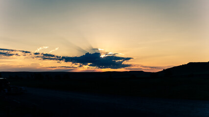 Panorama shot of colorful sunset behind clouds in Badland national park in america