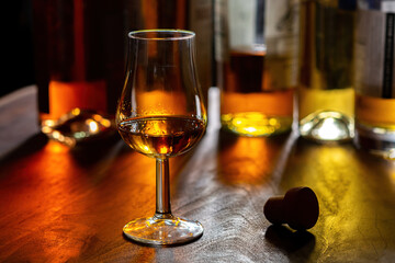 Dram of single malt scotch whisky and bottles on background