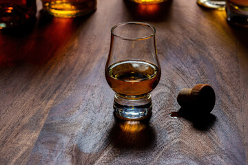 Dram of single malt scotch whisky and bottles on background