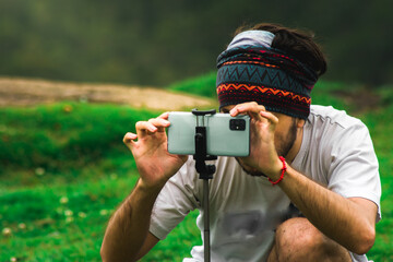 person taking a picture with a smartphone on a mountain