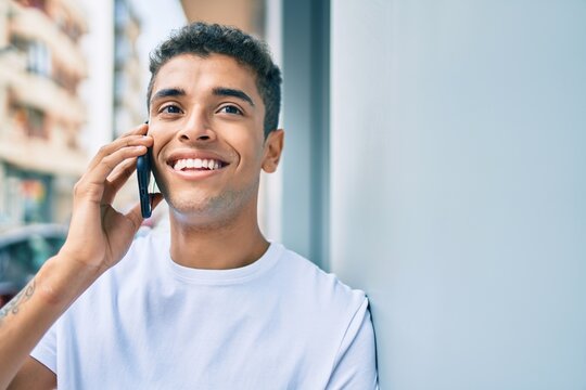 Young latin man smiling happy talking on the smartphone at the city.