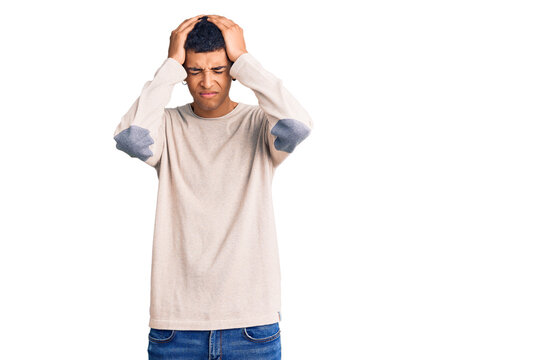 Young african amercian man wearing casual clothes suffering from headache desperate and stressed because pain and migraine. hands on head.
