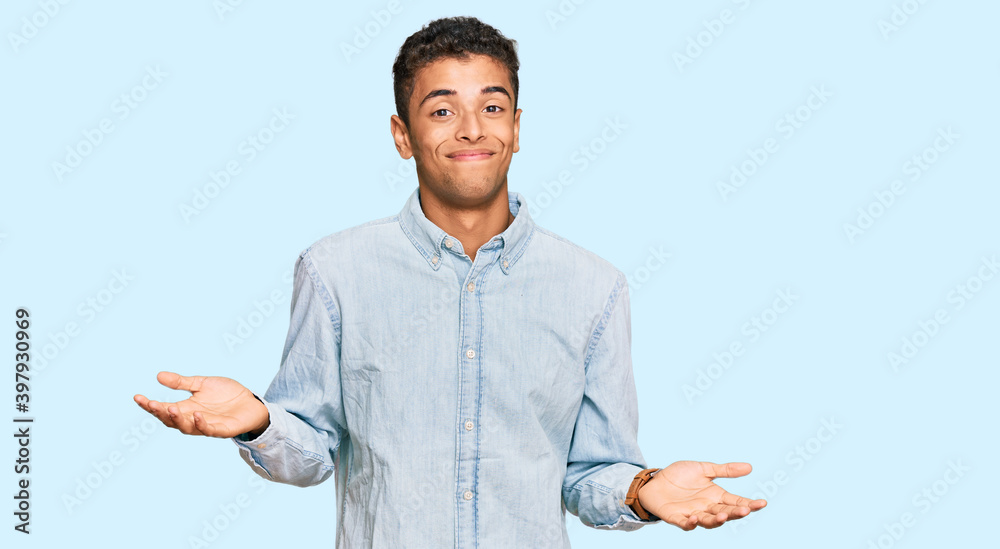 Sticker young handsome african american man wearing casual clothes clueless and confused expression with arm