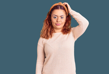Young latin woman wearing casual clothes and diadem confuse and wonder about question. uncertain...