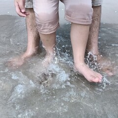 father and son kicking water