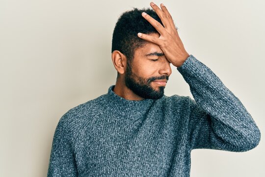 Handsome hispanic man with beard wearing casual clothes surprised with hand on head for mistake, remember error. forgot, bad memory concept.