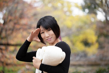 グローブを持ち笑顔で敬礼ポーズの女性